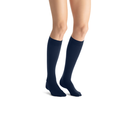 Navy knee-high socks worn by a person on a white background