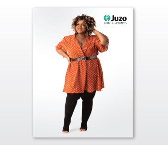 Model wearing orange belted dress against white studio background with Juzo branding – Compressionsale