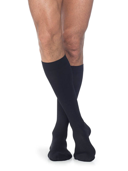 Black knee-high socks worn by a person on a white background