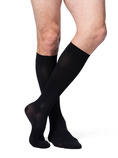 Black compression stockings worn by a person on a white background