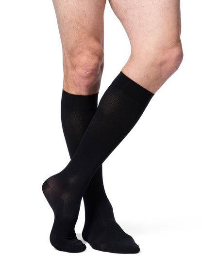 Black compression stockings worn by a person on a white background