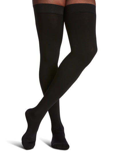 Black knee-high socks worn by a person on a white background