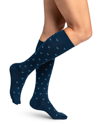 Navy blue knee-high socks with heart pattern worn by a person on a white background
