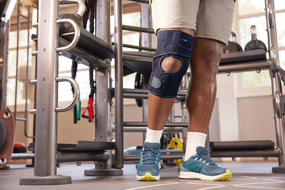 Person wearing a knee brace in a gym setting