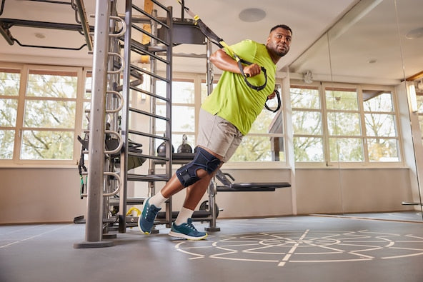 Man exercising with resistance bands in a gym setting