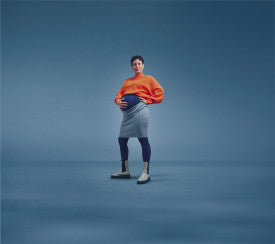 Person wearing an orange sweater and gray apron from Compressionsale against a blue background