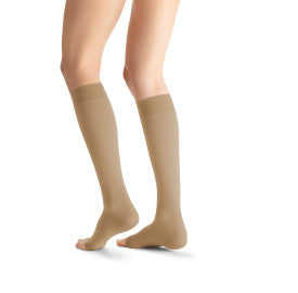 Beige knee-high socks worn by a person on a white background