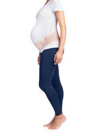 Pregnant person wearing navy leggings and a white top from Compressionsale on a white background
