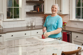 Woman in a kitchen preparing food while wearing gloves from Compressionsale.