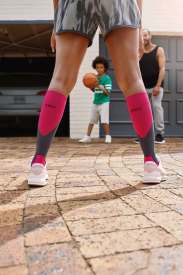 Person wearing colorful knee-high socks on a stone pavement