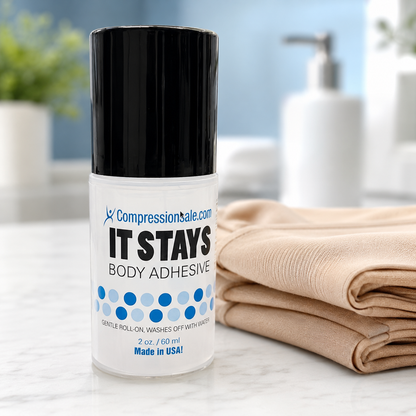 It Stays Body Adhesive roll-on next to folded beige compression stockings on a bathroom counter