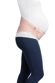Pregnant person wearing a pink abdominal support belt with navy leggings from Compressionsale on a white background