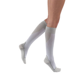Gray knee-high socks worn by a person on a white background