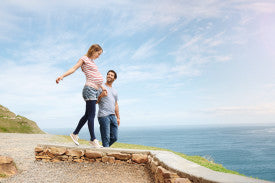 Two people walking along a coastal path with ocean and sky in the background from Compressionsale