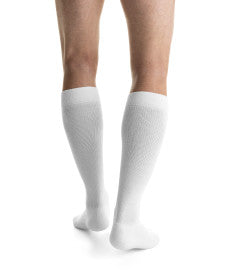 White knee-high socks worn by a person on a white background
