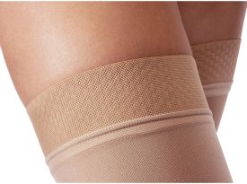 Close-up of beige compression stocking being worn on a leg.