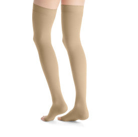 Beige knee-high socks worn by a person on a white background
