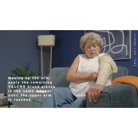 Woman with a cast on her arm sitting on a couch, using Velcro brand pieces.