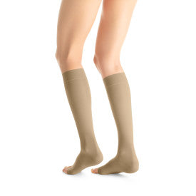 Beige knee-high socks worn by a person from Compressionsale on a white background.