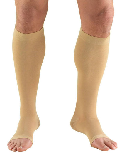 Beige compression stockings being worn on a white background