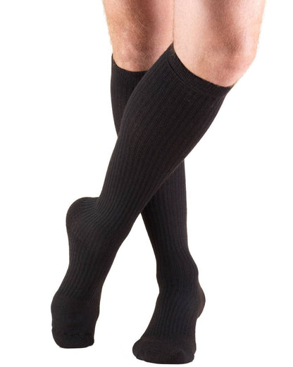 Black knee-high socks worn by a person on a white background