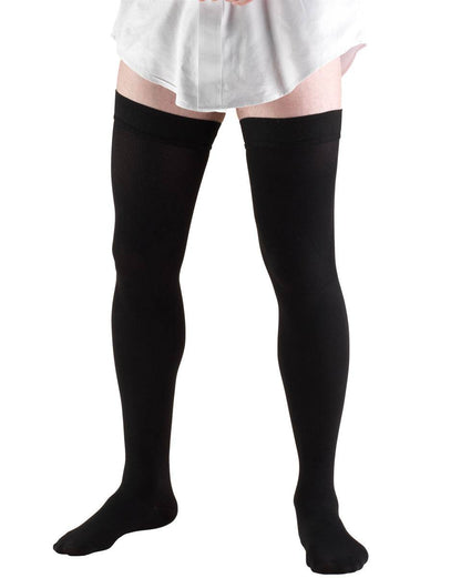 Black knee-high socks worn with a white skirt on a white background