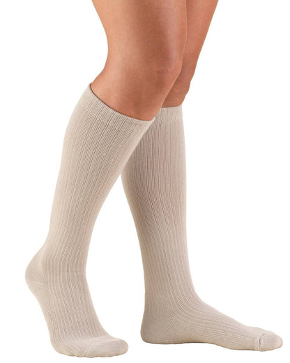 Tan knee-high socks worn by a person on a white background