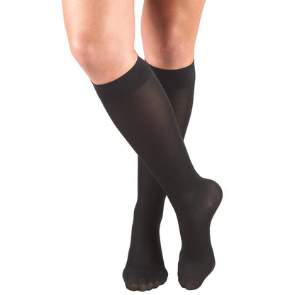Black compression stockings worn by a person on a white background