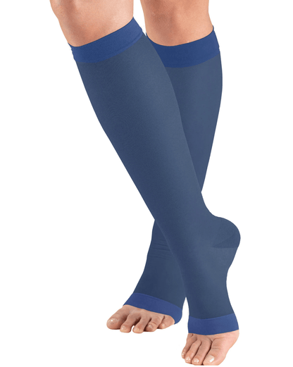 Blue compression stockings being worn on a white background