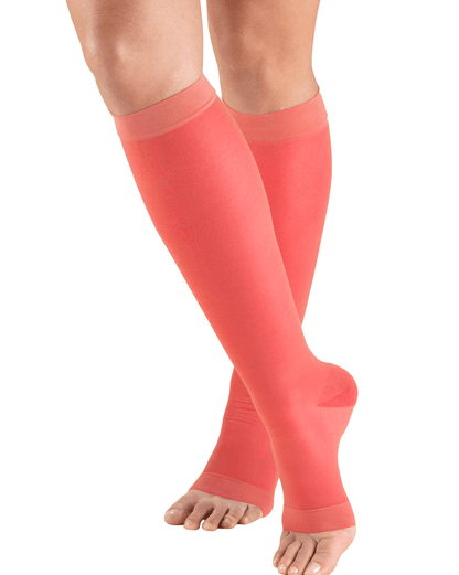 Pink compression stockings being worn on a white background